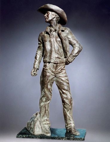 Cowboy statue in jeans and hat.