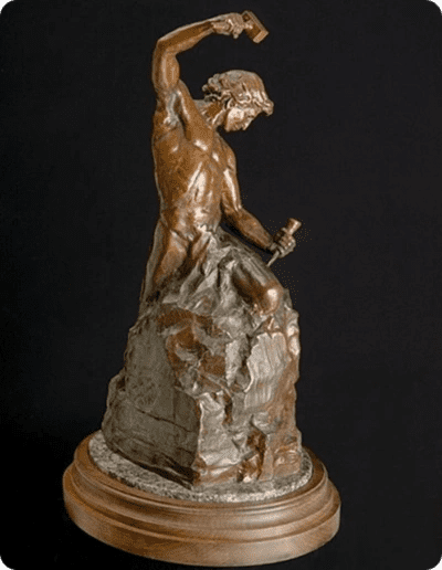 Bronze sculpture of a man chiseling stone.